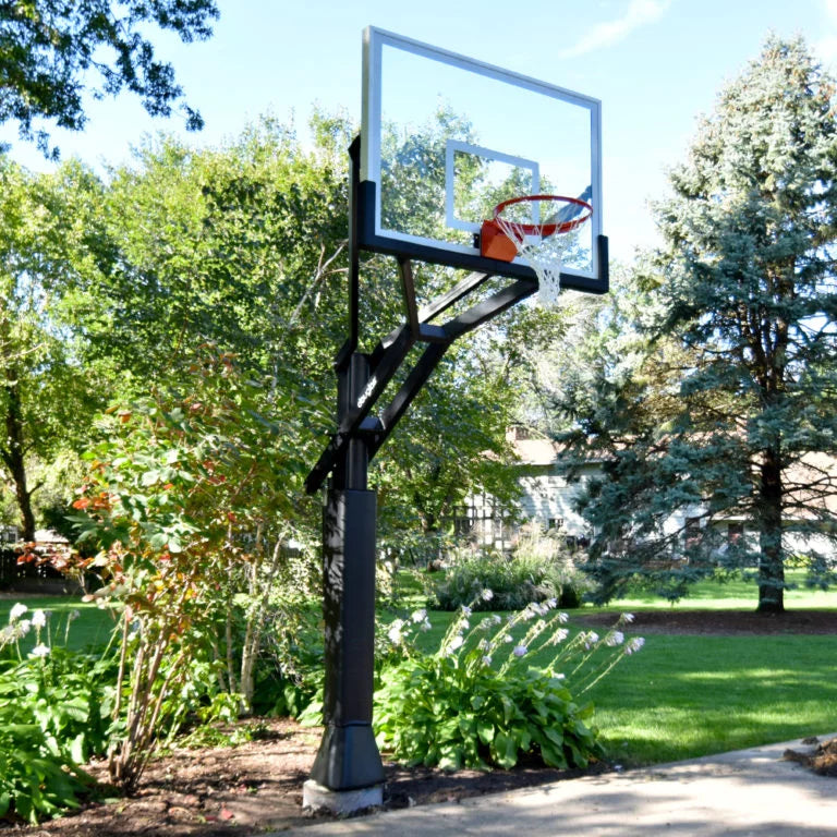 In-ground residential basketball hoop on a driveway with a house in the background