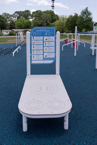 Children using the ActionFit Stretch Zone outdoor fitness station at a school playground