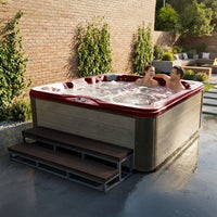 American Spas AMZ756B hot tub environment shot - Dark Cherry interior with Silver Oak cabinet