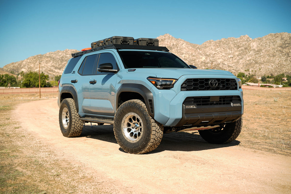 Blue 2025 Toyota 4Runner with off-road tires and DV8 Spec Series Roof Rack installed