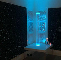 Fiber optic starfield carpet glowing with color-changing light points in a dark sensory room
