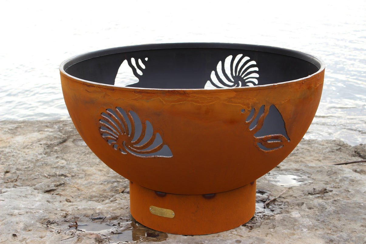 Beachcomber fire pit showing Conch and Nautilus shell cutout detail glowing with fire