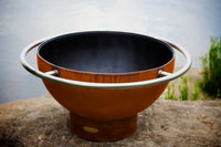 Fire Pit Art Bella Luna 48-inch steel fire pit with Iron Oxide Patina finish lit outdoors at night