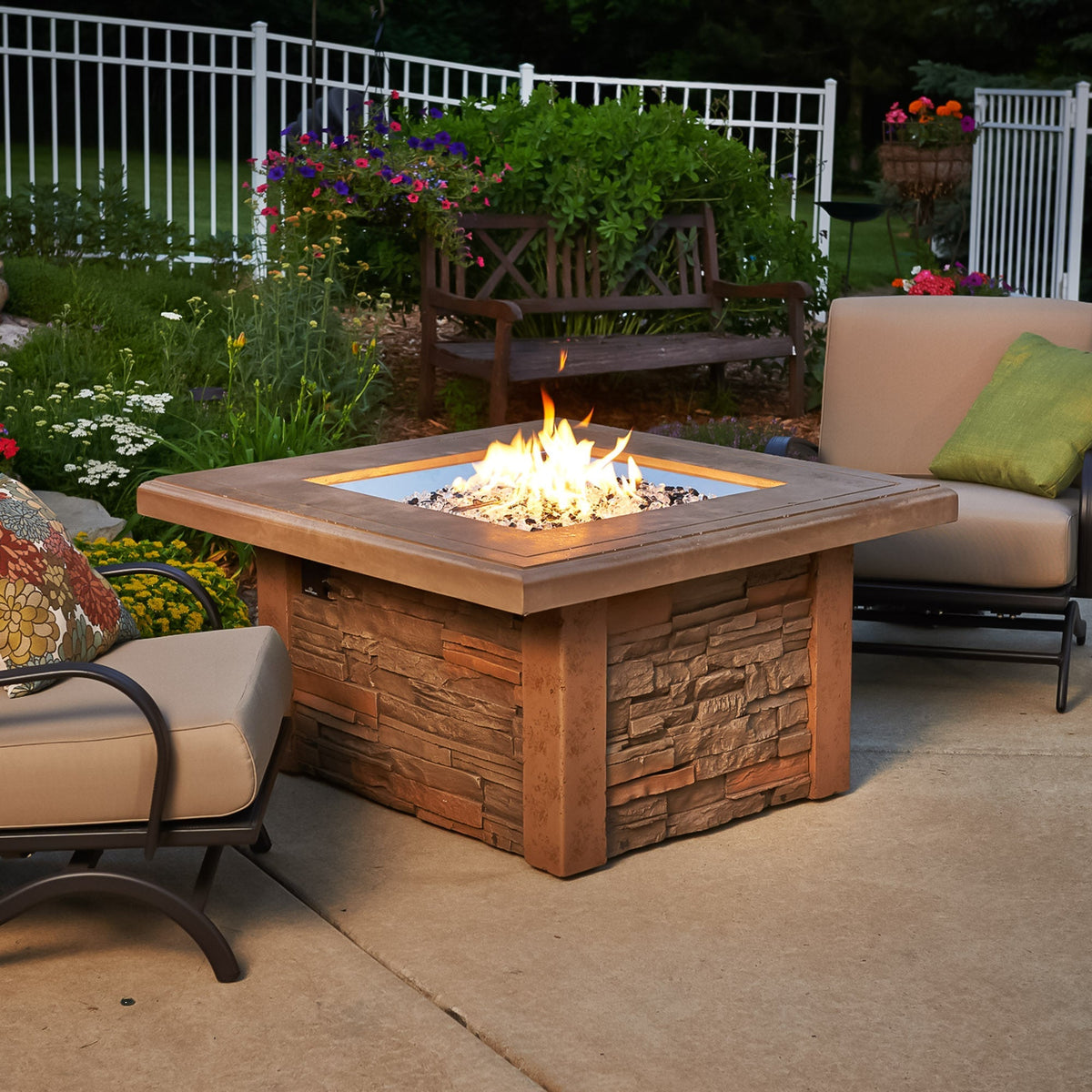 Sierra Square Gas Fire Pit Table on a patio surrounded by outdoor furniture