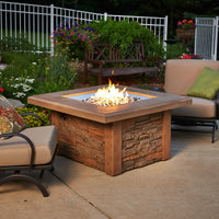 Sierra Square Gas Fire Pit Table on a patio surrounded by outdoor furniture