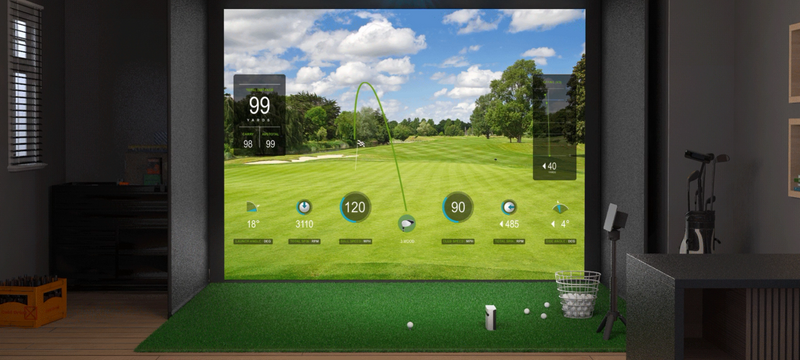 Indoor golf simulator room with virtual golf course on screen, turf mat, launch monitor, and golf club rack