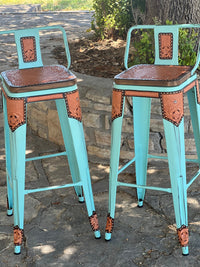 Set of 2 Alamo Saddlery 30-inch turquoise swivel bar stools with golden leather details and chocolate edge paint